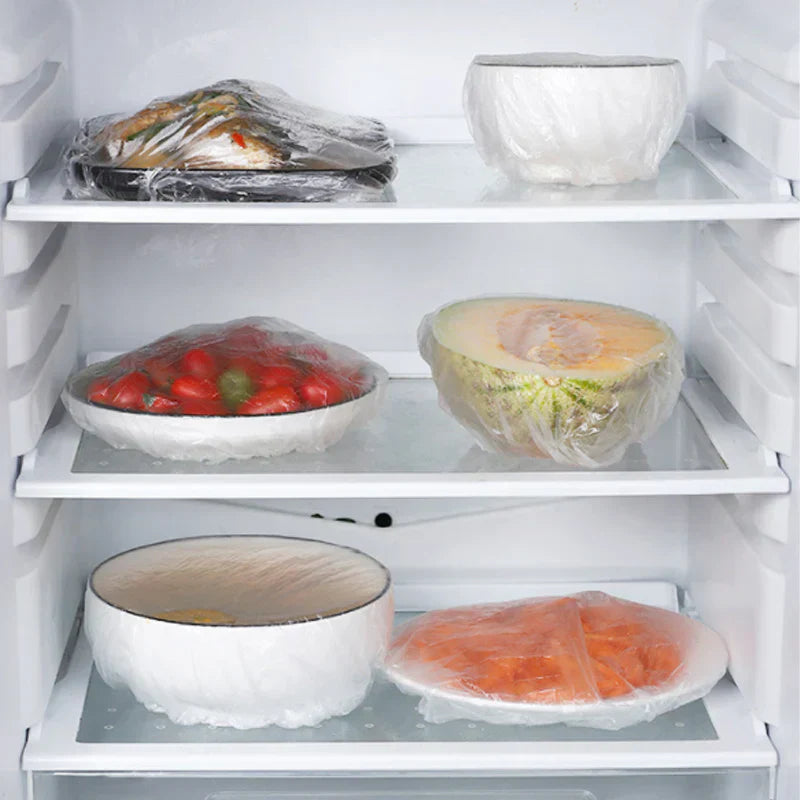 Mit PlasticWrap abgedeckte Schüsseln und Teller in einem Kühlschrank